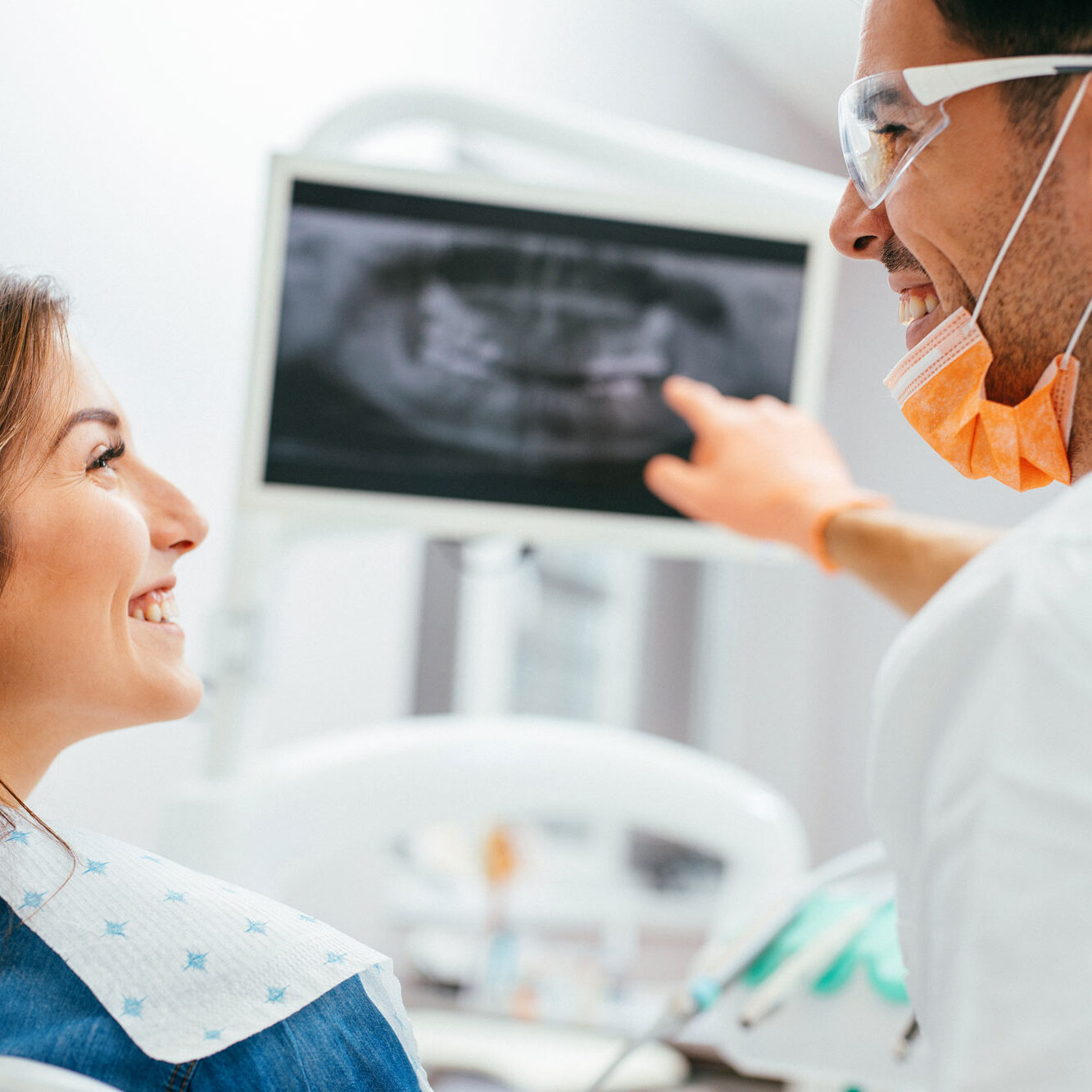 male-doctor-female-patient-pointing-at-xrays